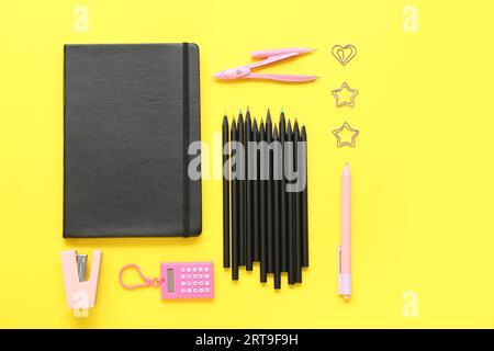Cancelleria scolastica con matite su sfondo giallo Foto Stock
