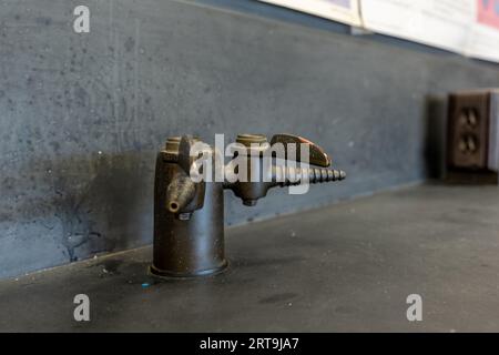 Valvola del gas su un tavolo da laboratorio in resina nera in un'aula di scienze delle scuole superiori. Foto Stock