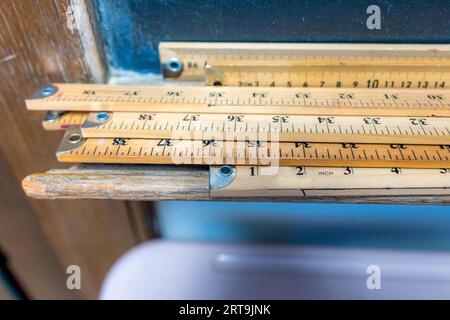 Gruppo di bastoncini in legno e bastoncini metrici con sfondo blu. Foto Stock