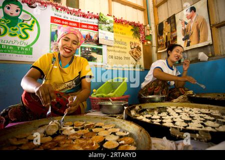 Koh Yao, Thailandia; 1° gennaio 2023: Un gruppo di donne che preparano dolci di cocco tradizionali dalle isole meridionali della Thailandia. Foto Stock