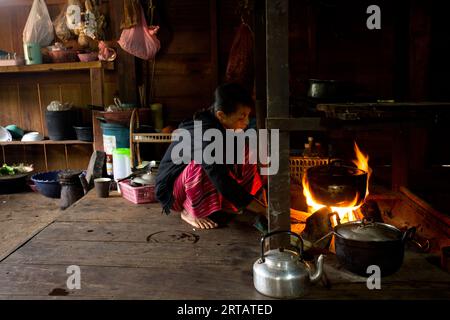 Chiang Rai, Thailandia; 1 gennaio 2023: Una tribù indigena donna proveniente dalle alte montagne del distretto di Chiang Rai che cucina nella sua casa. Foto Stock