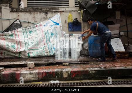 Bangkok, Thailandia; 1 gennaio 2023: Un uomo rompe un blocco di ghiaccio per le strade di Bangkok. Foto Stock