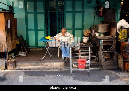 Bangkok, Thailandia; 1 gennaio 2023: Uomo che legge il giornale per strada. Foto Stock