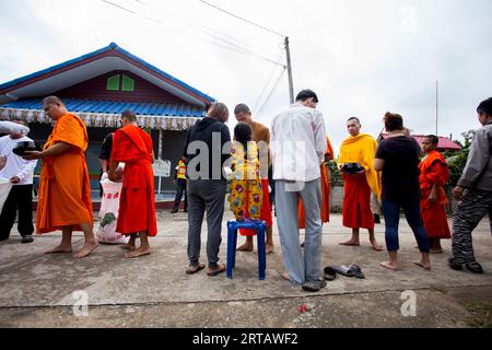 Chiang Rai, Thailandia; 1 gennaio 2023: La famiglia offre cibo ai monaci buddisti nella città di Chiang Rai. Foto Stock