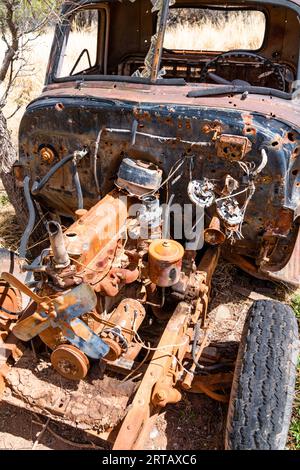 Naufragio di un'auto arrugginita lasciata indietro in un campo. Foto Stock