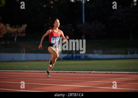 Atleta giapponese in esecuzione su via Foto Stock