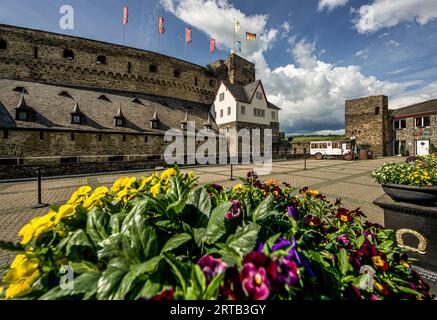 Vista sul cortile decorato con fiori dell'Hotel Schloss Rheinfels e sulla bailey esterna e l'area d'ingresso del Castello di Rheinfels, St. Goar, Upper M Foto Stock
