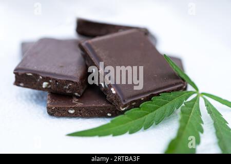 Delizioso brownie di cannabis con foglia di marijuana su sfondo bianco. Deliziosi biscotti spaziali. Foto Stock