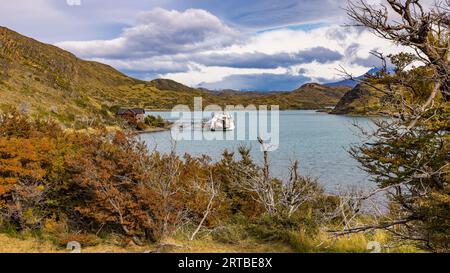 Un tour in barca è ormeggiato al molo del piccolo porticciolo nella baia settentrionale del lago Pehoe, al Parco Nazionale Torres del Paine, al Cile, alla Patagonia, all'Ameri del Sud Foto Stock