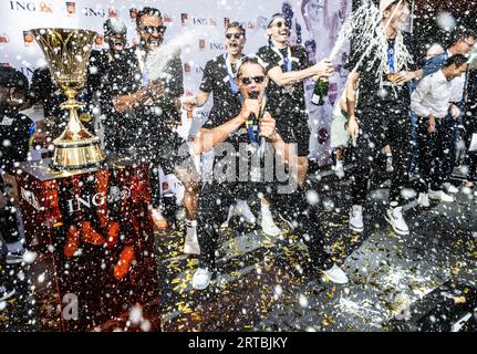 Assia, Francoforte, Germania. 12 settembre 2023, 12 settembre 2023, Assia, Francoforte sul meno: La nazionale di pallacanestro festeggia con una doccia di champagne al ricevimento della squadra a Francoforte. I giocatori di basket tedeschi sono stati accolti con entusiasmo a casa da circa 1000 tifosi dopo la loro sensazionale vittoria in Coppa del mondo. Foto: Boris Roessler/dpa Foto Stock