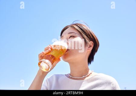 Donna giapponese che beve birra Foto Stock