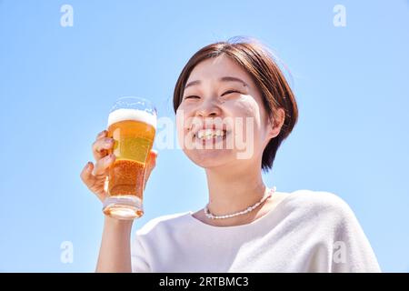 Donna giapponese che beve birra Foto Stock