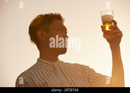 Un giapponese che beve birra Foto Stock
