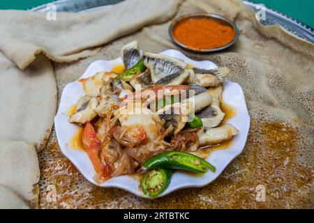 Pasto in Etiopia - peperoncino con peperoncino e verdure su pane piatto injera Foto Stock