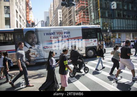 Persone e traffico stradale alla 42nd Street e alla 5th Avenue nel centro di Manhattan. Foto Stock