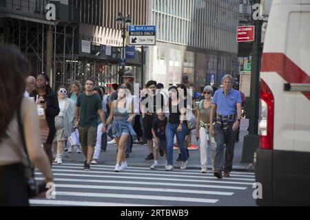 Persone e traffico stradale all'angolo sempre affollato tra la 42nd Street e la 5th Avenue nel centro di Manhattan. Foto Stock