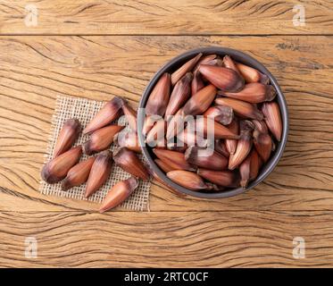 Pignoni o semi di pino su una ciotola su tavola di legno. Foto Stock