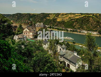 Vista dal Rheinburgenweg su ville e hotel di lusso vicino al Castello di Rheinfels, sullo sfondo una nave panoramica sul Reno, St Goar, Upper Middle Foto Stock