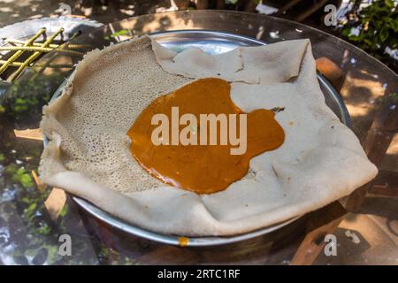 Pasto in Etiopia - Shiro Wat (stufato di ceci) su pane piatto injera Foto Stock