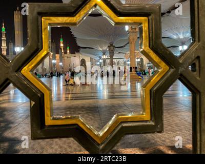 Medina, Arabia Saudita - 22 agosto 2023: I pellegrini camminano sotto ombrelli giganti nel complesso della Moschea Nabawi. Baldacchino a Masjid Nabawi a Medina, in Arabia Saudita Foto Stock