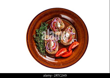 Tapas spagnole sul pane con olio d'oliva, erbe, pomodori e filetti di acciuga piccanti. Isolamento di alta qualità, sfondo bianco Foto Stock