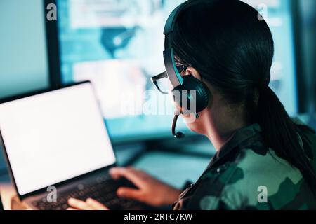 Centro di comando militare, schermo del computer e donna in mockup, cuffie e comunicazioni tecniche dal retro. Sicurezza, sorveglianza e soldato in bianco Foto Stock