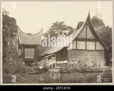 West Sumatra, Indonesia, 1900, foto d'archivio vintage, gruppo di uomini e bambini di fronte a una casa di Minangkabau, Foto Stock