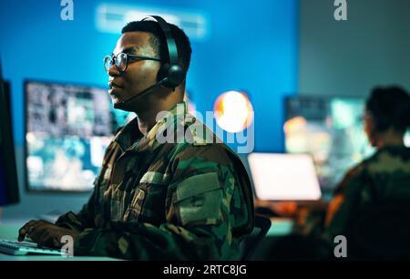Esercito, sala di controllo e uomo al computer in ufficio, data center e monitor per supporto tecnico, sicurezza informatica o sorveglianza. Militare, ufficiale o.. Foto Stock