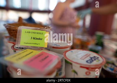 Berlino, Germania. 12 settembre 2023. "Bambini" è scritto su una carta durante la distribuzione in un punto di distribuzione "Laib und Seele" del Berliner Tafel nella comunità protestante della chiesa di Paolino, mostrando quanti prodotti alimentari una famiglia può ottenere. Credito: Sebastian Christoph Gollnow/dpa/Alamy Live News Foto Stock