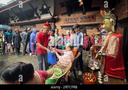 Kathmandu, Bagmati, Nepal. 12 settembre 2023. Le persone ricevono offerte distribuite dai devoti buddisti durante il festival Pancha Dan a Kathmandu, Nepal, 12 settembre 2023. Pancha Dan, la festa dei cinque doni estivi, è osservata dai buddisti donando cinque elementi tra cui cereali di grano, cereali di riso, sale, denaro e frutta. (Immagine di credito: © Sunil Sharma/ZUMA Press Wire) SOLO USO EDITORIALE! Non per USO commerciale! Crediti: ZUMA Press, Inc./Alamy Live News Foto Stock