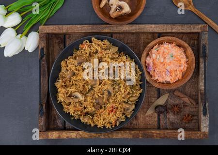 Gustosi funghi o riso Mashroom o Pulav o Pilaf o Pulao o Biryani serviti in ciotola o piatto. Delizioso riso fritto ai funghi con sfondo isolato. Foto Stock