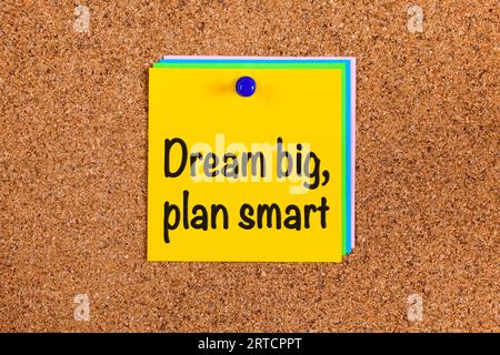 Nota gialla con le parole Dream Big, Plan Smart su un battistrada Foto Stock