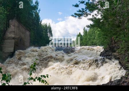 cascata durante le chiuse aperte per lo scarico inattivo dell'acqua in una piccola centrale idroelettrica Foto Stock