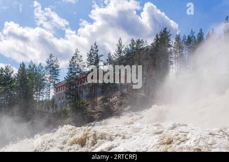 cascata durante le chiuse aperte per lo scarico inattivo dell'acqua in una piccola centrale idroelettrica Foto Stock