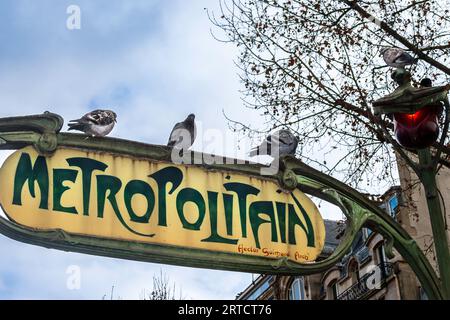 Un cartello per la stazione della metropolitana di Parigi, con i piccioni e le luci a forma di tulipano Foto Stock