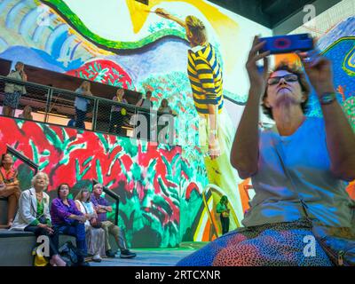 I visitatori della mostra "David Hockney: Bigger & Closer (Not Small & Further Away)" con proiezione su larga scala presso The Lightroom in King's Cross , Londra, fotografare e godersi l'esperienza immersiva di martedì 12 settembre 2023. David Hockney porta i visitatori in un viaggio personale attraverso sessant'anni della sua arte. Le vaste pareti e il rivoluzionario sistema audio di Lightroom consentono ai visitatori di vivere il mondo attraverso gli occhi di Hockney. La mostra si svolge fino al 3 dicembre 2023. Credito: Rob Taggart/Alamy Live Foto Stock