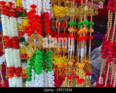 Fiori artificiali multicolori utilizzati per la decorazione del festival Diwali, appesi all'interno di un negozio, il giorno prima del festival Diwali e Ganesh Foto Stock