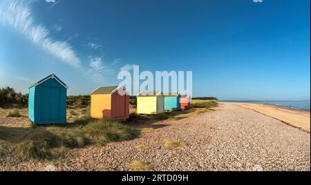 Findhorn Moray Scotland un cielo blu e cinque rifugi o chalet colorati che si affacciano sulla spiaggia e sul mare Foto Stock