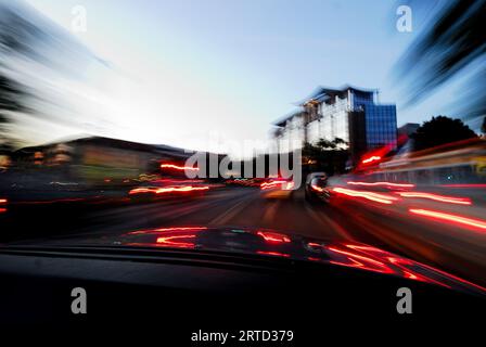 Guida notturna in macchina, astratto, asfalto, auto, automobile, sfocatura, sfocato, auto, città, paesaggio urbano, curva, scuro, cruscotto, centro, drive, Foto Stock