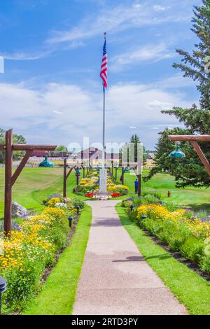 Bandiera americana e giardini di fiori all'ingresso del Glacier Park Lodge a East Glacier, Montana. Foto Stock