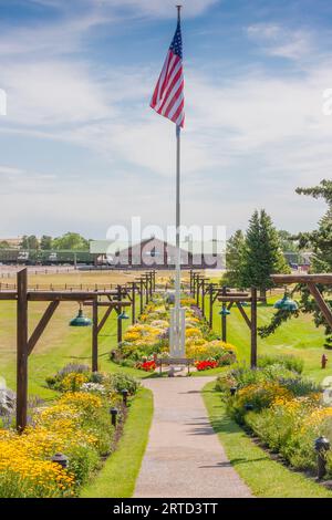 Bandiera americana e giardini di fiori all'ingresso del Glacier Park Lodge a East Glacier, Montana. Foto Stock