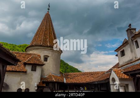 Una pittoresca scena architettonica con un edificio coperto di tegole rosse: All'interno del castello di Dracula a Bran, Romania Foto Stock