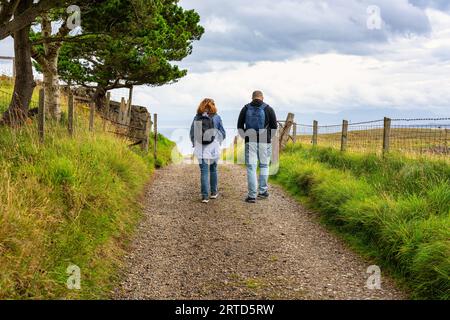 Un paio di uomini e donne che camminano lungo un sentiero sull'Isola di Skye, Scozia, Regno Unito. Foto Stock