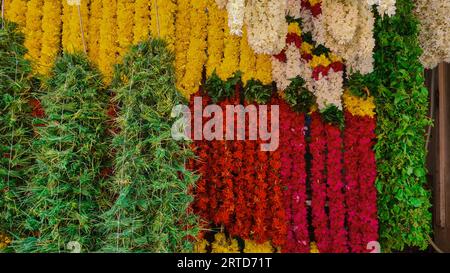 Scatto di una serie di ghirlande di fiori appese a un negozio di fiori. Foto Stock