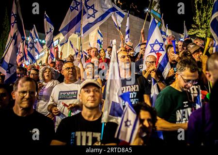 Gerusalemme, Israele. 11 settembre 2023. Una folla di manifestanti anti anti-riforma sventola le bandiere israeliane durante una manifestazione a Gerusalemme. Migliaia di manifestanti anti-governativi israeliani si sono radunati fuori dalla Corte Suprema lunedì, alla vigilia di una storica udienza su un'offerta della coalizione del primo ministro Benjamin Netanyahu per frenare i poteri della corte. Credito: SOPA Images Limited/Alamy Live News Foto Stock