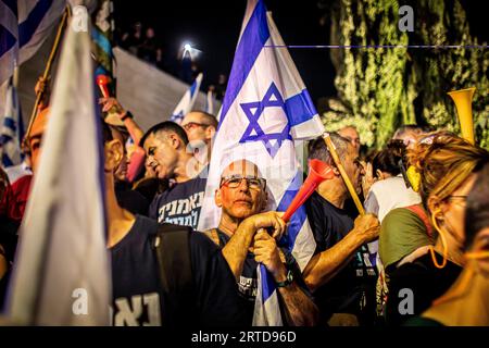 Gerusalemme, Israele. 11 settembre 2023. Un manifestante anti-riforma si trova accanto a una bandiera israeliana durante una manifestazione a Gerusalemme migliaia di manifestanti anti-governativi israeliani si sono radunati fuori dalla Corte Suprema lunedì, alla vigilia di un'audizione storica su un'offerta della coalizione del primo ministro Benjamin Netanyahu di limitare i poteri della corte. (Immagine di credito: © Eyal Warshavsky/SOPA Images via ZUMA Press Wire) SOLO PER USO EDITORIALE! Non per USO commerciale! Foto Stock