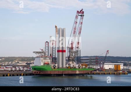 Nave da costruzione di mulini a vento carica di alberi ormeggiati a Cherbourg, Francia Foto Stock