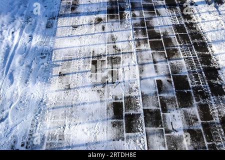 Percorsi pneumatici su strade coperte da neve in una vista ravvicinata Foto Stock
