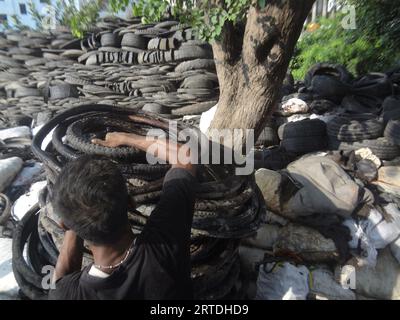 Dhaka, Bangladesh. 13 settembre 2023. Vicino a un negozio di pneumatici usati a Dacca, un operaio carica pneumatici usati su un camion per la consegna. Il terreno di riproduzione per le larve di zanzara di Aedes, che trasmettono la dengue, può essere trovato nell'acqua piovana stagnante su pneumatici usati. Secondo fonti mediche, 618 persone nel paese sono morte di dengue quest'anno e 194 nuovi casi sono stati confermati entro 24 ore. (Immagine di credito: © MD Mehedi Hasan/ZUMA Press Wire) SOLO USO EDITORIALE! Non per USO commerciale! Foto Stock