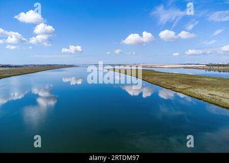 Vista aerea con droni della foce del fiume Tinto. Estuario del Rio Tinto nelle paludi di Huelva con un bel riflesso del cielo Foto Stock